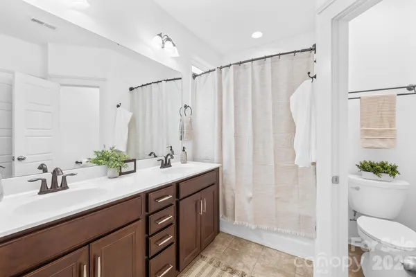 a bathroom with a double vanity sink toilet and shower
