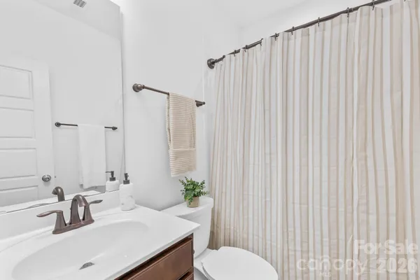 a bathroom with a sink a toilet and shower curtain