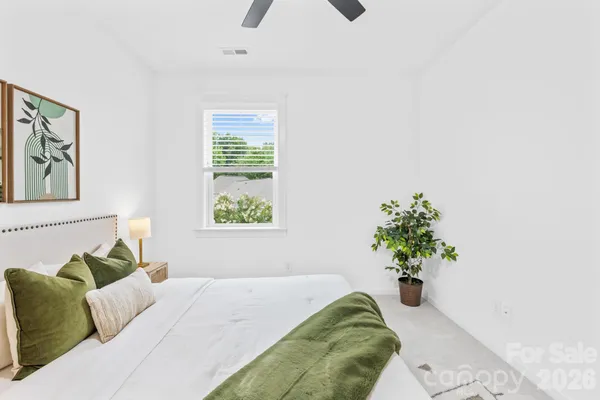 a bed sitting in a bedroom next to a window