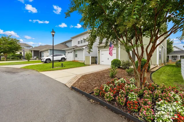 a front view of a house with garden and trees
