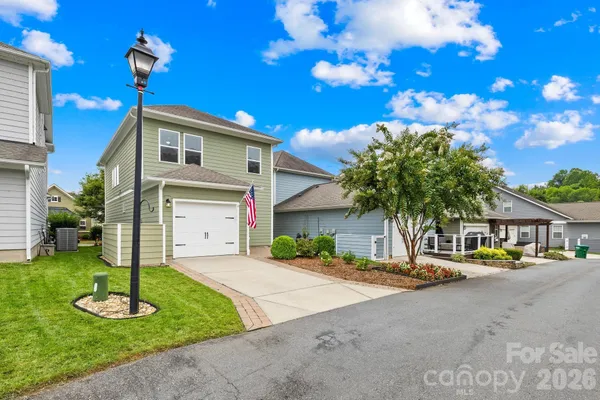 a front view of a house with garden and trees