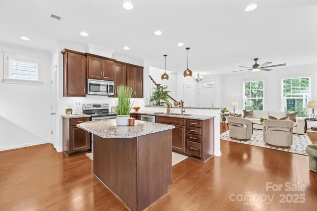 a kitchen with kitchen island granite countertop a sink counter top space and stainless steel appliances