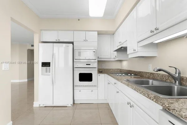 a kitchen with white cabinets and white appliances