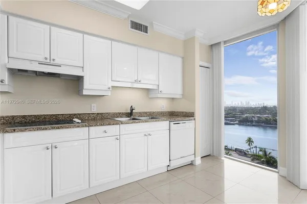 a kitchen with granite countertop white cabinets and stainless steel appliances