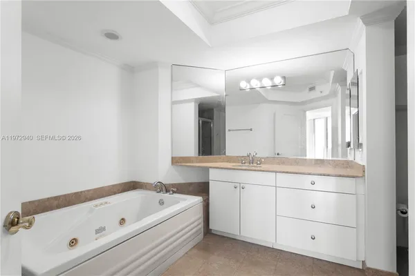 a bathroom with a tub a sink and mirror