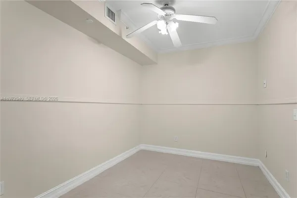 an empty room with a window and ceiling fan