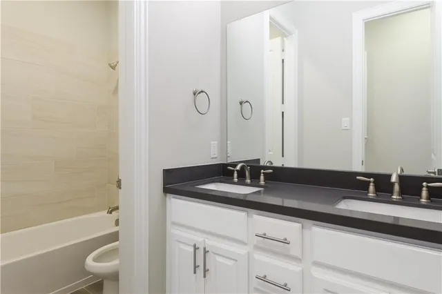 a bathroom with a granite countertop sink a toilet and a bathtub