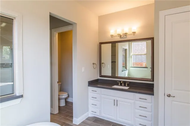 a bathroom with a sink a toilet and a mirror