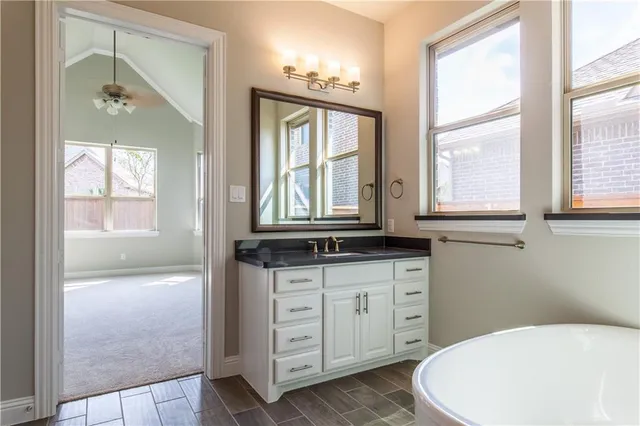 a bathroom with a granite countertop toilet a sink and a large mirror
