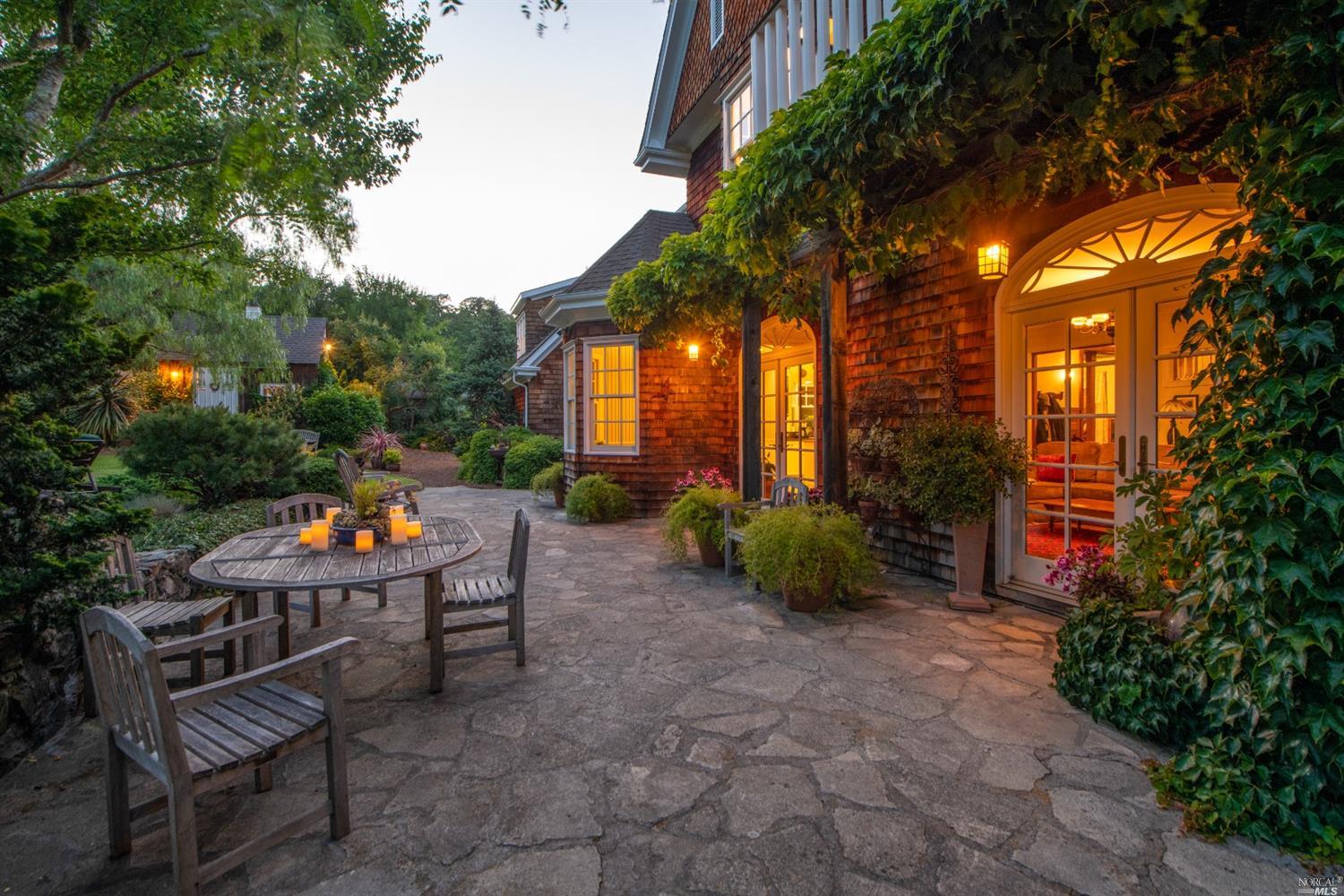 a backyard of a house with barbeque oven table and chairs