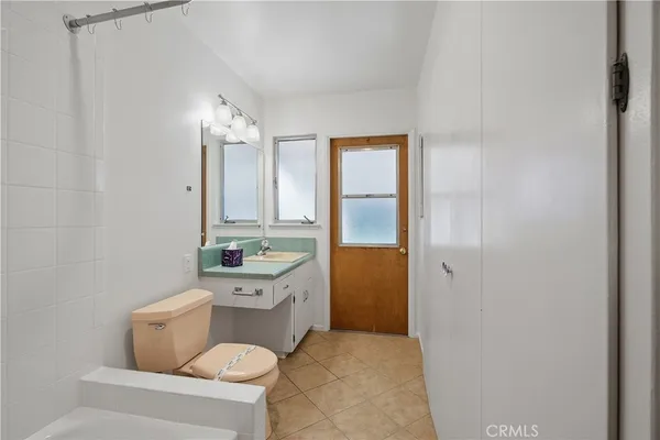 a bathroom with a granite countertop sink a toilet and mirror