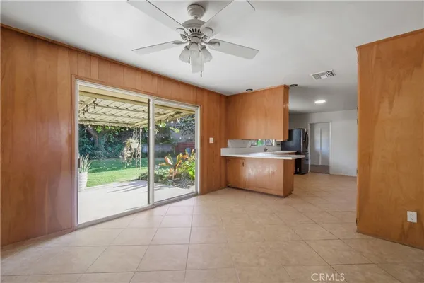 a large kitchen with stainless steel appliances a large counter top a sink and a chandelier