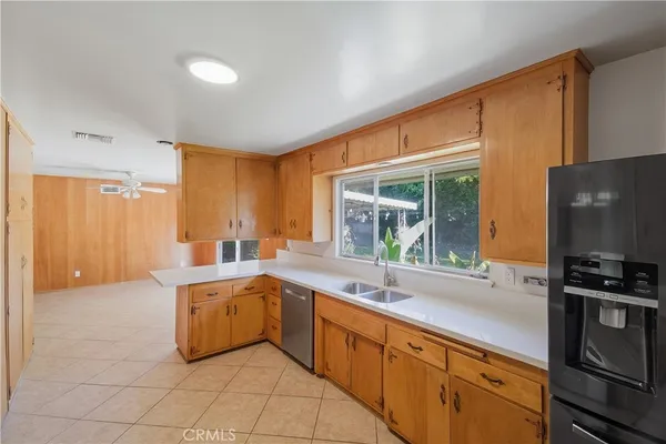 a large white kitchen with a sink and a large window