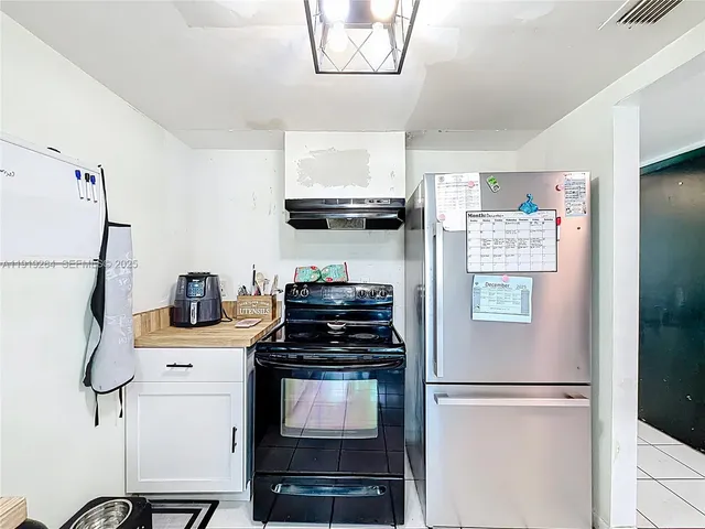 a kitchen with a refrigerator and a stove top oven