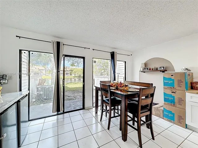 a dining room with furniture and large windows