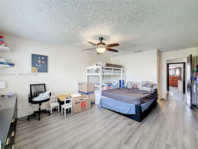a spacious bedroom with a bed and a chandelier