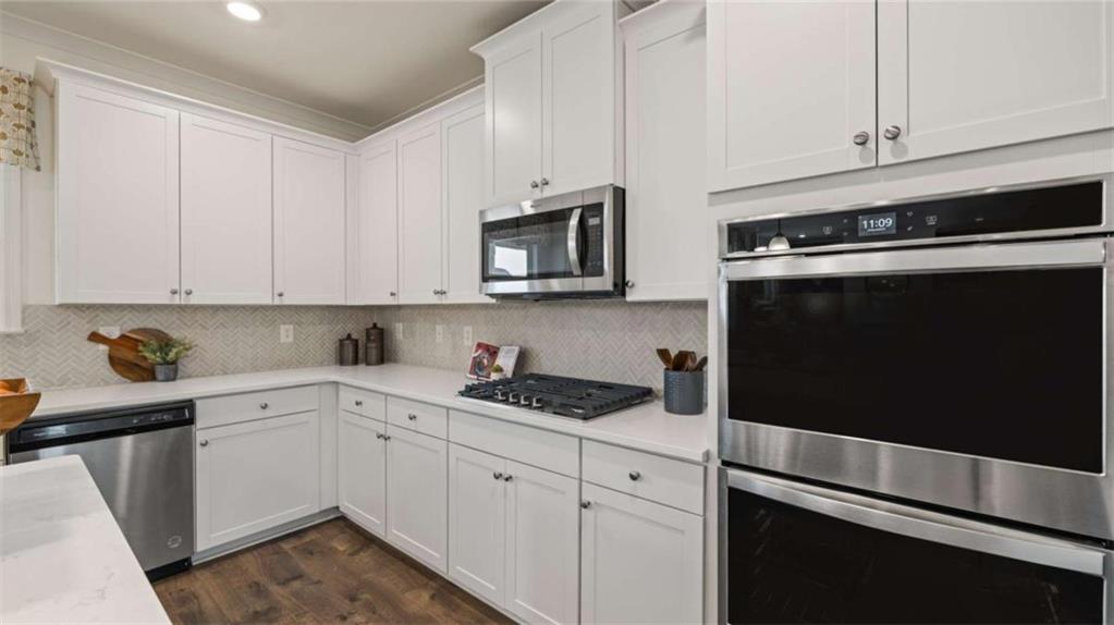 687 Edgar Street Hampton, GA 30228 - Photo 20 of 79 a kitchen with granite countertop white cabinets and black appliances