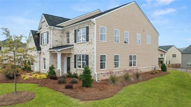 an aerial view of a house with a garden and lake view