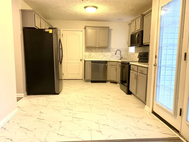 a kitchen with stainless steel appliances a refrigerator and a stove
