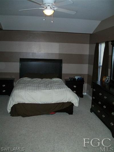 8329 Trillium Road Fort Myers, FL 33967 - Photo 8 of 10 a bedroom with a bed and a television