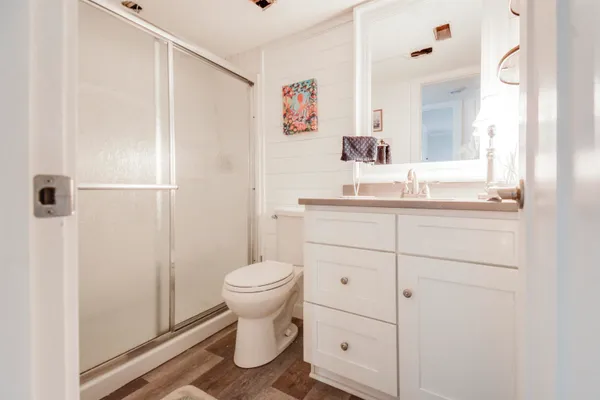 a bathroom with a sink a toilet and shower