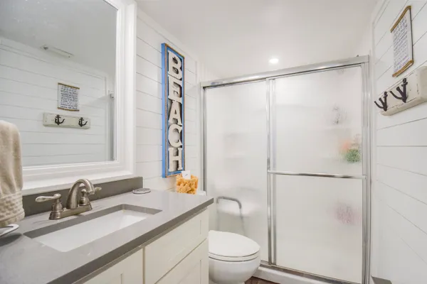 a bathroom with a granite countertop sink toilet and shower