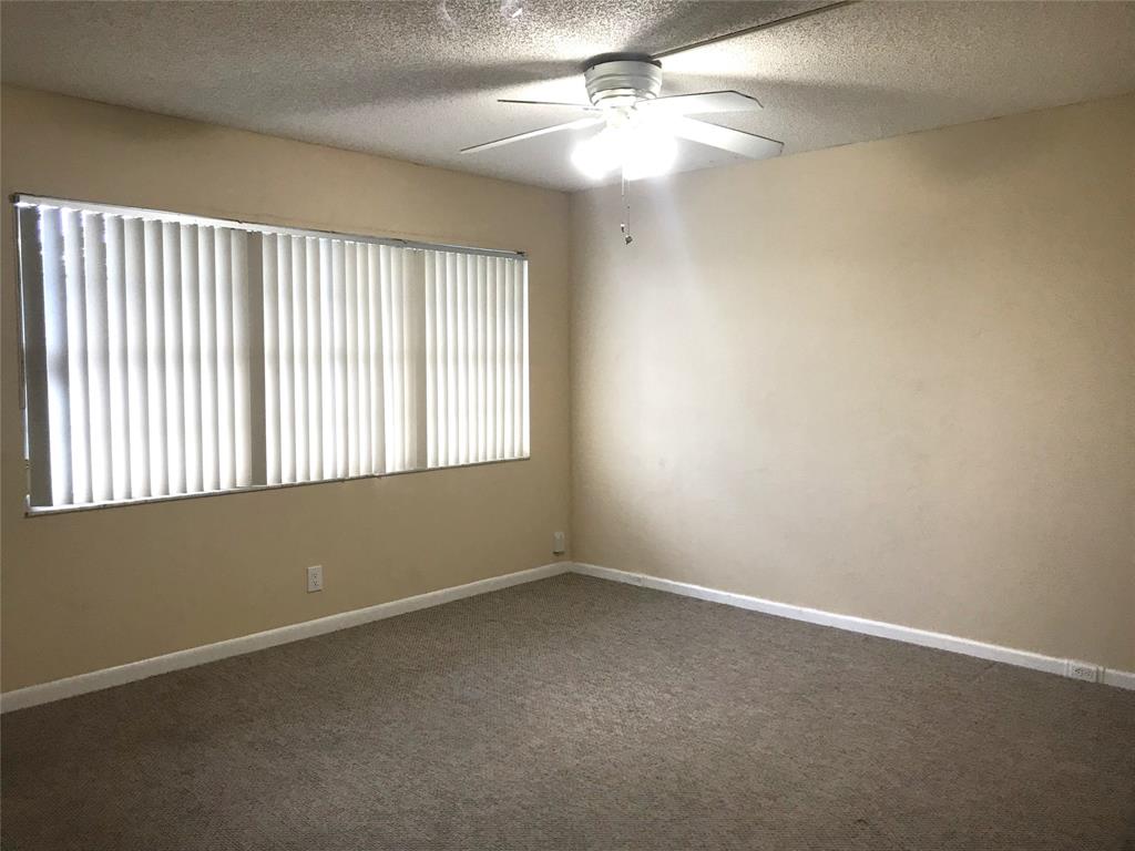 1401 Southwest 135th Terrace, Unit 307H Pembroke Pines, FL 33027 - Photo 3 of 13 an empty room with a window and a fan