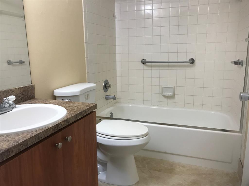 1401 Southwest 135th Terrace, Unit 307H Pembroke Pines, FL 33027 - Photo 5 of 13 a bathroom with a granite countertop toilet a sink and bathtub