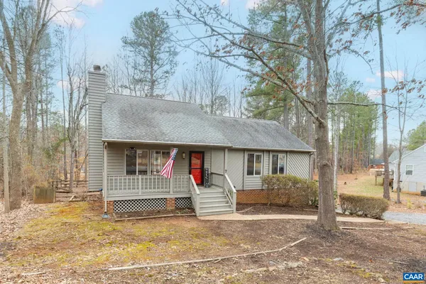 a view of a house with a yard and large tree