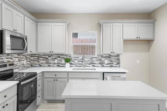 a kitchen with stainless steel appliances white cabinets and a sink