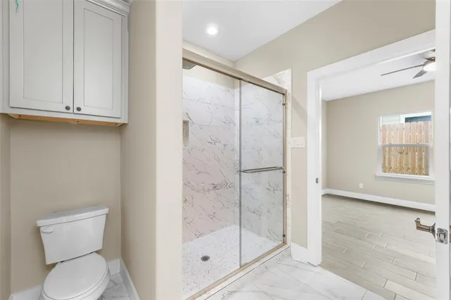 a bathroom with a shower a toilet and a sink