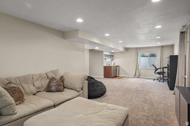 955 Delorean Lane Midvale, UT 84047 - Photo 37 of 47 Spacious open area featuring recessed lighting, a built-in wet bar with wood-finish cabinetry, a single window with blinds, and light-colored carpeting