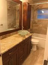 a bathroom with a granite countertop sink toilet and shower