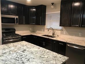 8926 Angleton Place Dallas, TX 75243 - Photo 4 of 19 a kitchen with stainless steel appliances kitchen island granite countertop a sink stove and cabinets