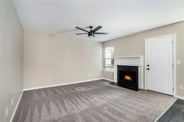 an empty room with windows and a fireplace