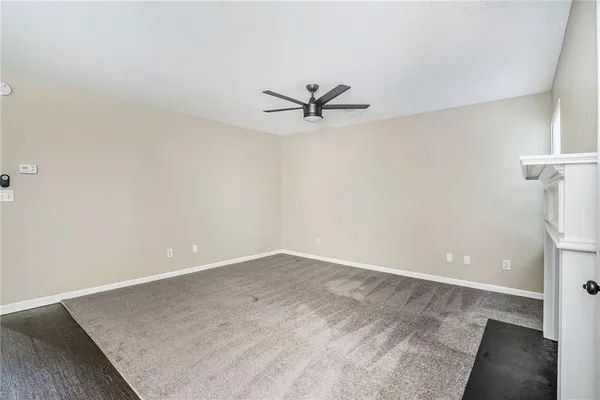 an empty room with a ceiling fan and a window