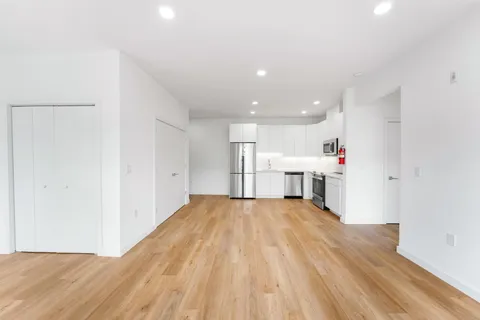 a view of a kitchen with wooden floor and windows