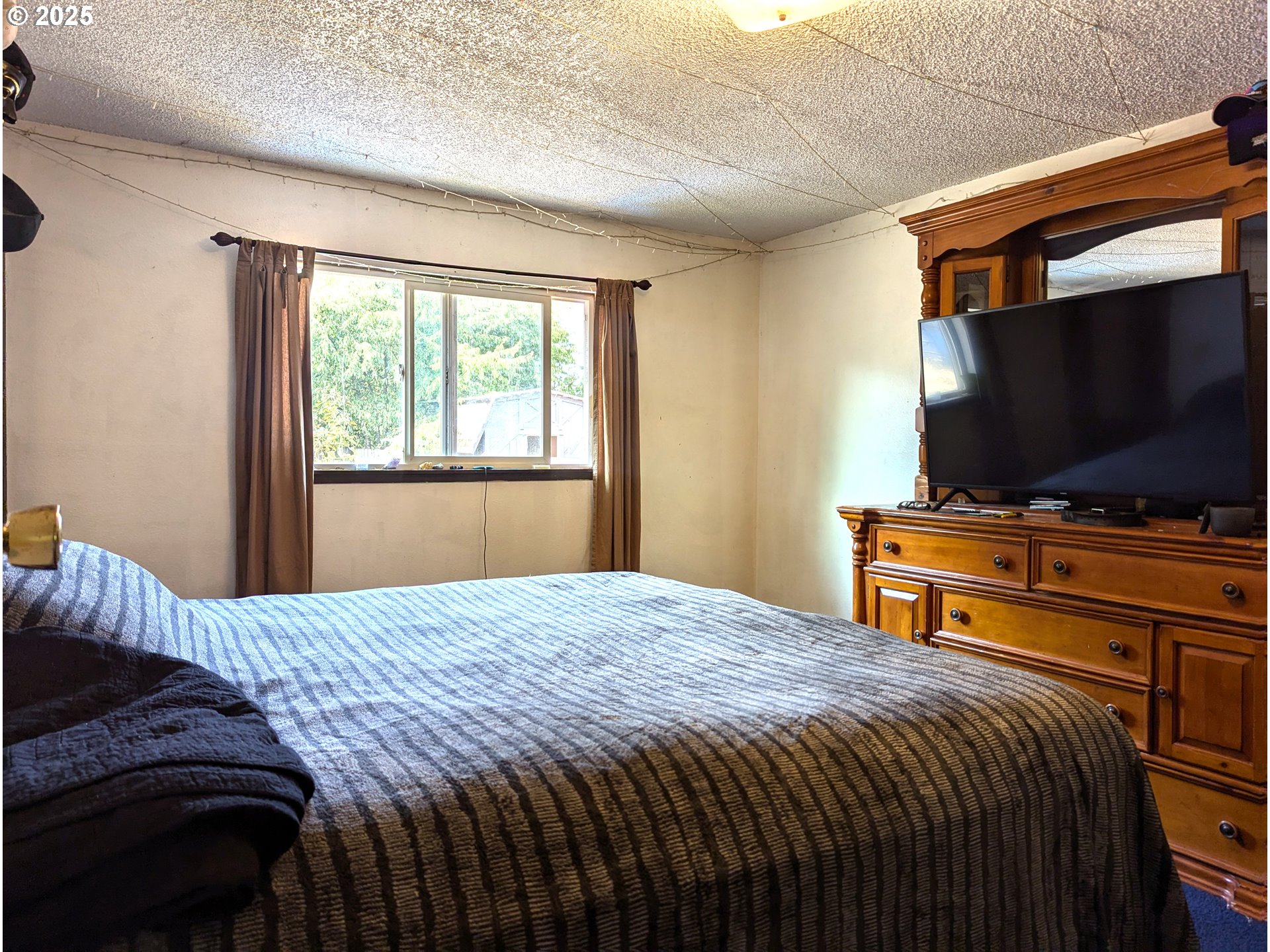 47696 West 1st Street Oakridge, OR 97463 - Photo 6 of 20 a bedroom with a bed and a flat screen tv