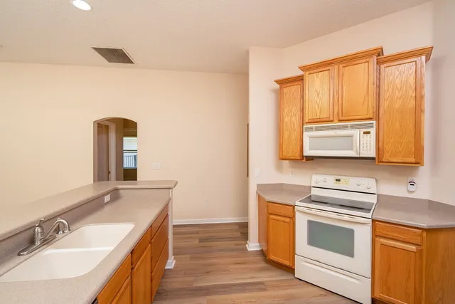 a view of a room with a ceiling fan and wooden floor