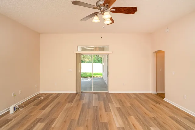 a view of a room with wooden floor and a ceiling fan