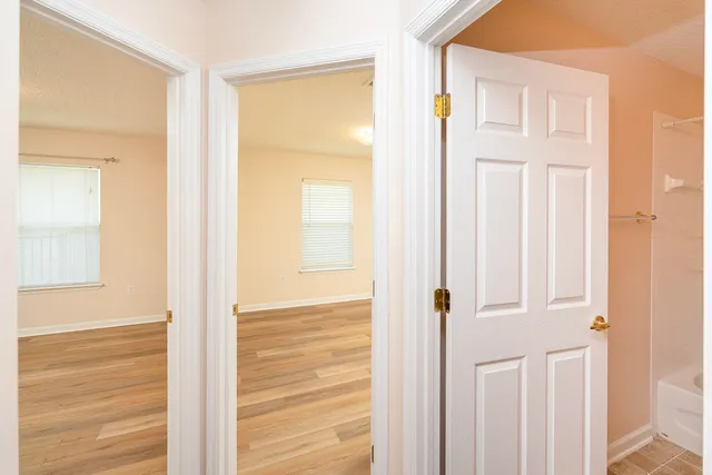 an empty room with wooden floor and windows