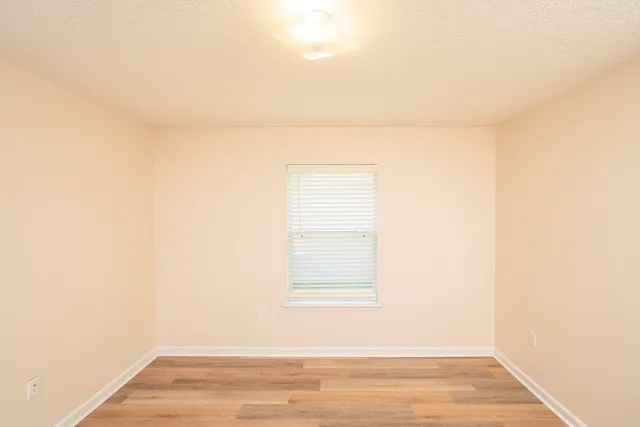 a view of a small space with wooden floor and a window