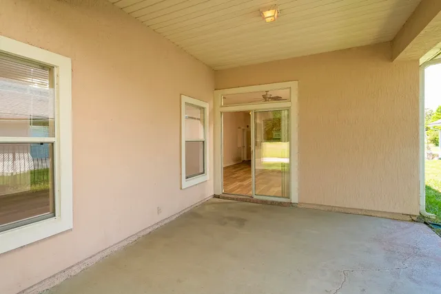 a view of a house with a big yard and large tree