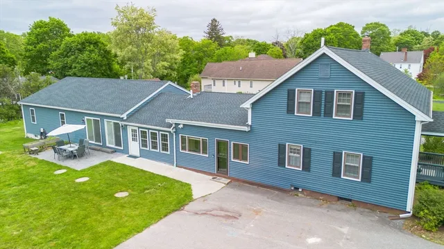 a aerial view of a house with a yard potted plants and a bench