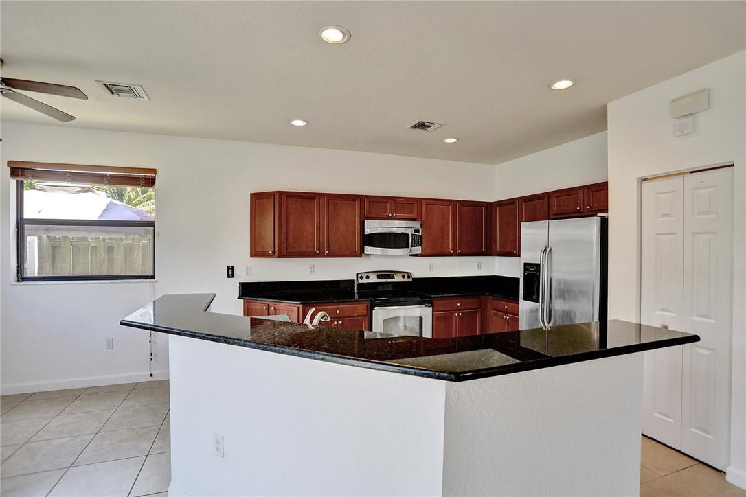 11331 Southwest 240 Lane Homestead, FL 33032 - Photo 19 of 92 a kitchen with stainless steel appliances granite countertop a sink refrigerator and microwave