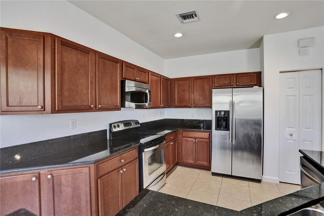 11331 Southwest 240 Lane Homestead, FL 33032 - Photo 21 of 92 a kitchen with stainless steel appliances granite countertop a refrigerator and a stove top oven