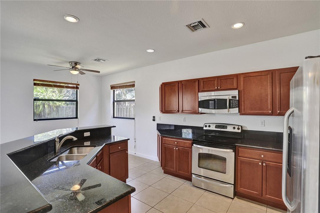 11331 Southwest 240 Lane Homestead, FL 33032 - Photo 22 of 92 a kitchen with stainless steel appliances granite countertop a sink stove top oven and microwave