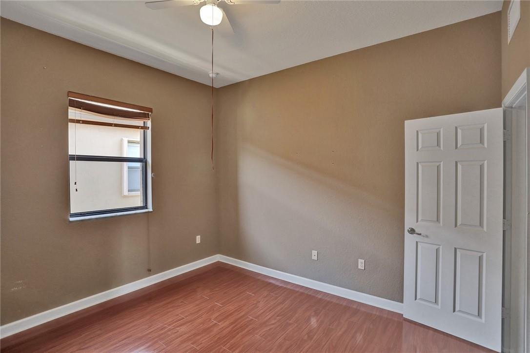 11331 Southwest 240 Lane Homestead, FL 33032 - Photo 62 of 92 a view of an empty room with wooden floor and a window