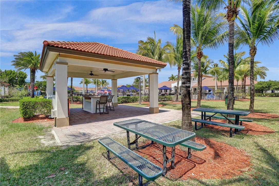 11331 Southwest 240 Lane Homestead, FL 33032 - Photo 77 of 92 a roof deck with table and chairs potted plants and a palm tree