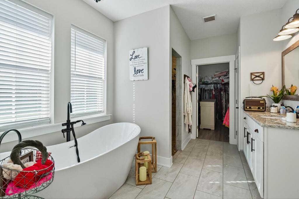 75774 Edwards Road Yulee, FL 32097 - Photo 46 of 70 a bathroom with a tub sink and mirror